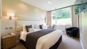 een hotelkamer met een groot bed en een raam bij The Devon Hotel in Exeter