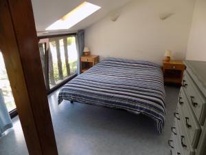 ein Schlafzimmer mit einem Bett mit einer gestreiften Decke in der Unterkunft Gite 4 Logis Gascons in Saint-Justin
