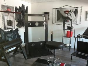 um quarto com uma cadeira e um espelho na parede em Exclusiv-Mietapartment (BDSM)-Heidelberg em Heidelberg