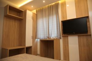 Schlafzimmer mit einem Flachbild-TV und einem Fenster in der Unterkunft Gold Crown Apartments in Jagodina