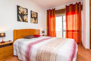 una camera da letto con un letto e una finestra di Apartamentos Arcada a Quarteira
