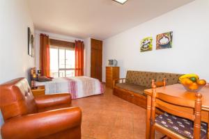 una camera con divano, letto e tavolo di Apartamentos Arcada a Quarteira