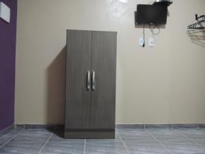 a wooden cabinet in a room with a tv at Pousada Centaurus in Alto Paraíso de Goiás