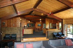 uma sala de estar em plano aberto com paredes e tectos em madeira em Westwood Lodge em Franz Josef