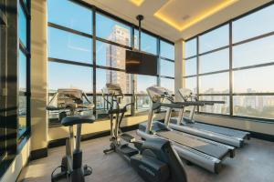 a gym with cardio machines in a building with windows at I am Design Hotel Campinas by Hotelaria Brasil in Campinas