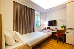 um quarto de hotel com uma cama, uma secretária e uma janela em The Sultan em Singapura