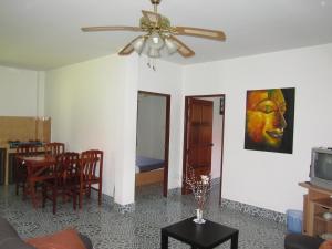ein Wohnzimmer mit einem Deckenventilator und ein Esszimmer in der Unterkunft Smile House & Pool in Rawai Beach