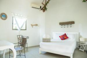 a white bedroom with a bed and a table and chairs at Harmony Glamping Boutique Hotel and Yoga in Tulum