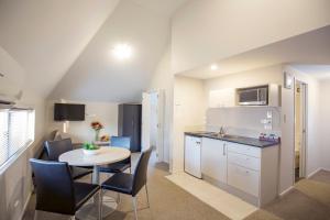 a kitchen and dining room with a table and chairs at Vita Nova Motel in Christchurch