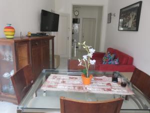 a living room with a glass table and a red couch at Seu Lugar Em Copacabana in Rio de Janeiro