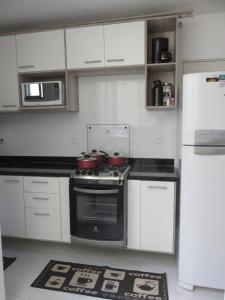 a kitchen with white cabinets and a stove top oven at Seu Lugar Em Copacabana in Rio de Janeiro