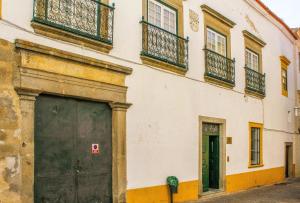 een gebouw met een grote deur en een balkon bij Casa De S. Tiago in Évora
