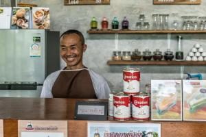 Un homme debout derrière un comptoir dans un restaurant dans l'établissement Baan Suan Duang Porn Resort, à Ban Phae