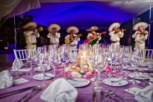 een groep mensen die instrumenten spelen aan een tafel met wijnglazen bij Casa Violeta in Tulum