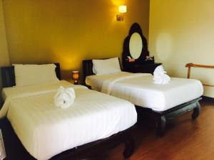 two beds in a hotel room with towels on them at Baan Sang Singh in Chiang Mai