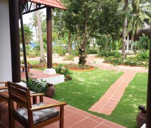a patio with a lawn and a garden with palm trees at Peppercorn Beach Resort in Phú Quốc