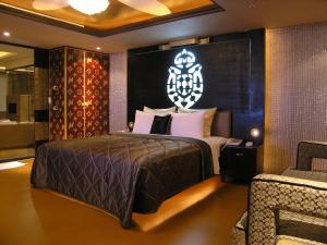 a bedroom with a large bed with a chandelier above it at Miho Boutique Motel in Zhonghe