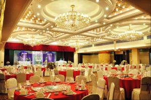 a banquet hall with red tables and chairs and chandeliers at Merry Hotel Shanghai in Shanghai