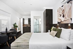 
a hotel room with a bed, chair, and table at North Adelaide Boutique Stays Accommodation in Adelaide
