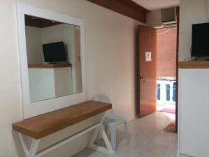 a room with a desk with a mirror and a chair at InnBox Bed & Bath in Panglao Island