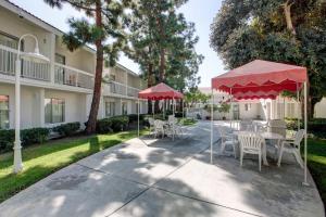 un patio con mesas y sillas frente a un edificio en Motel 6-Santa Ana, CA - Irvine - Orange County Airport en Santa Ana