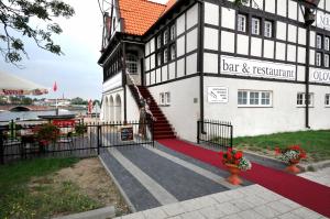 a black and white building with a red carpet at Ołowianka B&B in Gdańsk