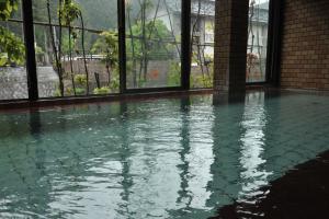 a pool of water in a building with windows at Atarashiya Ryokan in Tenkawa