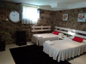 a bedroom with two beds and a clock on the wall at Casa Carola in Oia