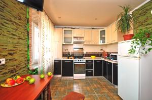 a kitchen with black cabinets and a table with fruits on it at Gagarina avenue in Kharkiv +4 photos