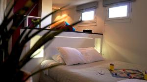 a bed in a room with two windows at Hotel-Restaurant Lann Roz / Côte Cuisine in Carnac