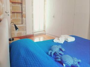 Una cama con sábanas azules y toallas. en Brezza Marina, en Polignano a Mare