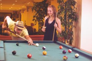 a man and a woman playing a game of pool at Titan Club Hotel Ultra All Inclusive in Kargicak