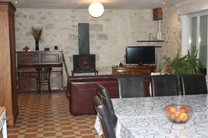 a living room with a table and a television at Le Dolmen in Primelin