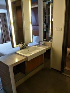 a bathroom with a sink and a bed and a mirror at Goldmet Inn Taiyuan Dananamen in Taiyuan