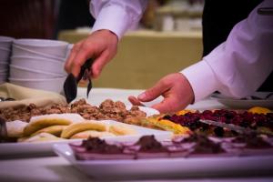 un chef está preparando comida en una mesa en Hotel San Giacomo, en Cesenatico