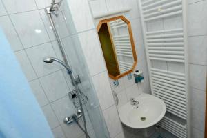 a white bathroom with a sink and a mirror at Apartment House Koprivnik in Zreče