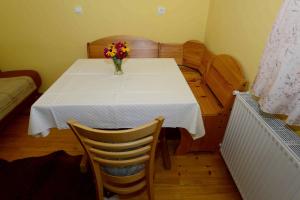a dining room table with a vase of flowers on it at Apartment House Koprivnik in Zreče