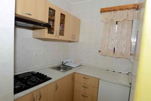 a small kitchen with a sink and a stove at Apartment House Koprivnik in Zreče