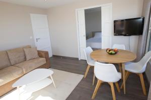 Una sala de estar con un sofá, una mesa y sillas. en Le Rooftop 180, en Villefranche-sur-Mer