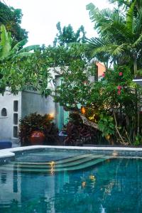 a swimming pool in a yard with trees and plants at The Island Houses Seminyak in Seminyak