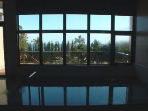 an empty room with a window looking out at trees at Yakushima Green Hotel in Yakushima