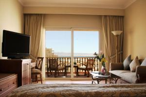 a living room with a television and a room with a balcony at Kempinski Hotel Soma Bay in Hurghada