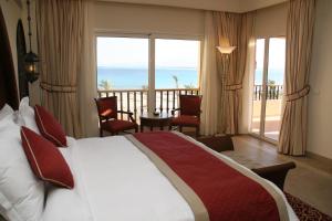 a bedroom with a bed and a view of the ocean at Kempinski Hotel Soma Bay in Hurghada