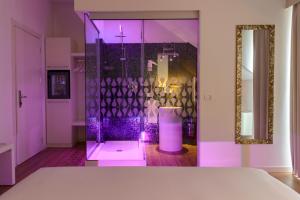 a purple room with a glass shower with a table at Elite Hotel & Spa in Mestre