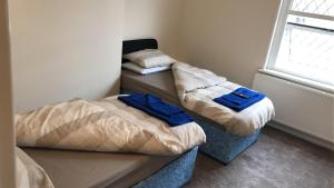 2 Betten in einem kleinen Zimmer mit Fenster in der Unterkunft The Victoria in Wakefield