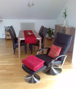 a dining room with a table and chairs with red cushions at Ferienwohnung Susanne Kiefer in Nonnenhorn