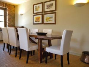 a dining room with a wooden table and white chairs at Casale Umbro in Castiglione del Lago