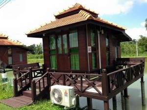 Sarocha Resort Rayong في Ban Nong Ri: منزل صغير مع مروحة في الماء