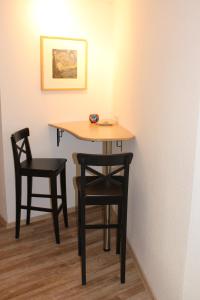stół z dwoma krzesłami i stołem w obiekcie Pension Holly w mieście Oschatz