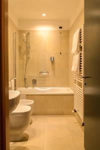 a bathroom with a toilet and a tub and a sink at Elite Hotel & Spa in Mestre